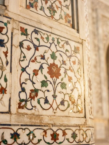 Close-up of intricate marble inlay work on the Taj Mahal during golden hour, warm sunlight illuminating the semi-precious stones, soft depth of field.