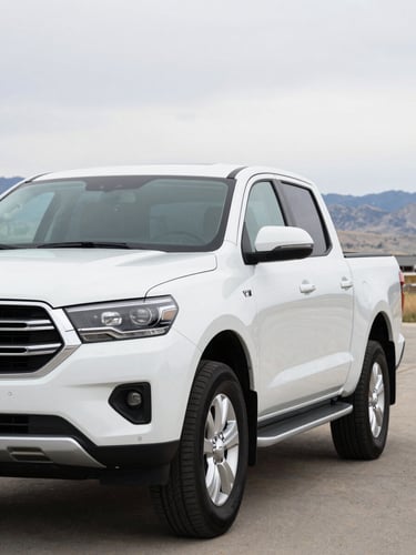 A clean, modern white 4x4 pickup truck parked outdoors in Pocatello, Idaho, soft overcast daylight, sharp 35mm automotive shot.