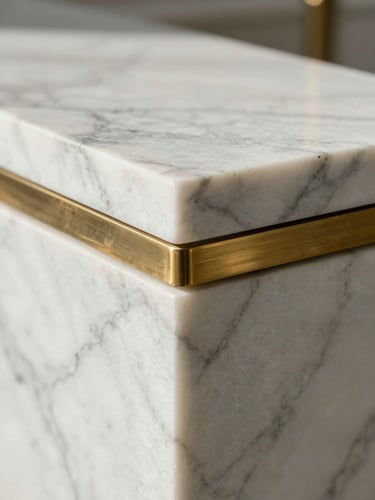 Macro close-up of premium white Carrara marble meeting brushed brass inlay, natural soft morning light, architectural detail focus.