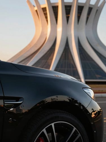 Cinematic close-up of a polished black luxury sports car fender reflecting the iconic concrete curves of Brasília's Cathedral at golden hour, sharp metallic reflections, deep shadows.