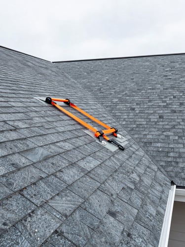 Wide-angle architectural view of a residential shingle roof installation in Queens, crisp daylight, slate gray GAF shingles, safety-orange harness detail visible