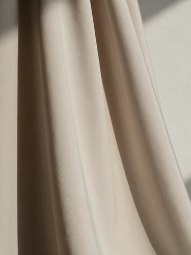 Extreme macro close-up of heavy silk crepe drape, soft directional natural light casting deep architectural shadows on a neutral wall, minimalist editorial fashion photography