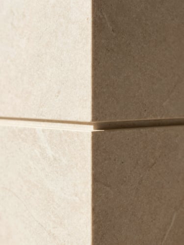Close-up macro shot of premium custom millwork joints, natural stone veining, soft diffused daylight, warm architectural minimalism, 35mm