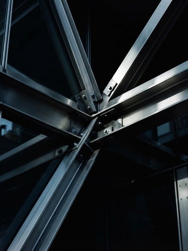 Macro detail of sharp architectural steel lines reflecting directional morning light, deep blacks and cool silver tones, dark cinematic photography, 35mm