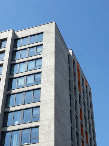 Low-angle architectural crop of a concrete and glass skyscraper corner slicing into a bright blue sky, sharp shadows, high-key natural daylight.