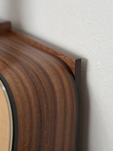 Macro close-up of custom walnut acoustic slats meeting a clean plaster wall, soft side lighting highlighting the tactile wood grain and precise alignment.