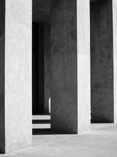Stark black and white architectural photography, harsh direct sunlight hitting concrete pillars, deep geometric shadows, minimalist composition, 35mm film
