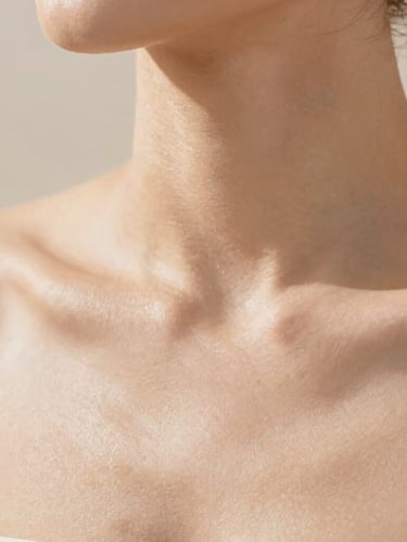 Close-up of clean, healthy skin with natural texture under soft, warm natural daylight, minimalist clinical aesthetic, warm sand tones, shallow depth of field, 35mm photography