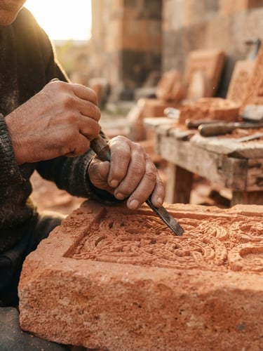 Close-up of an Armenian artisan's hands carving intricate geometric patterns into warm volcanic tufa stone, natural golden-hour side-light, shallow depth of field, authentic workspace.