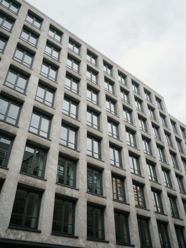 Wide-angle view from street level looking up at a modernist Berlin apartment building facade, neutral overcast daylight, geometric window grid receding upward, no people, clinical framing