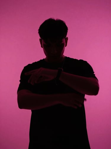 Frame from a music video — performer silhouetted against a saturated magenta cyclorama, hard edge lighting, motion blur on hands, high contrast grade