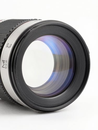 High-precision optical lenses catching light, clean studio light, crisp white background, subtle blue refractions, 50mm lens