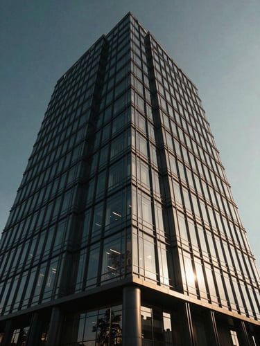 Low-angle shot of a sleek, modern corporate headquarters building in Istanbul, glass and steel architecture, dramatic architectural lighting, deep navy and champagne gold tones.