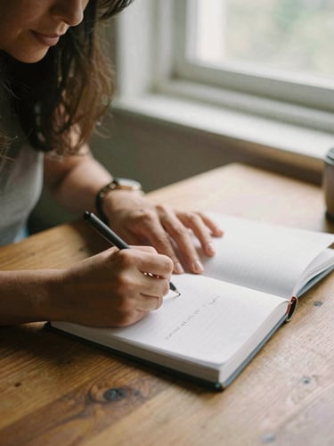Close-up of a Latina woman's hands writing notes in a physical planner on a wooden table, warm natural window light, organic feel, 35mm film.