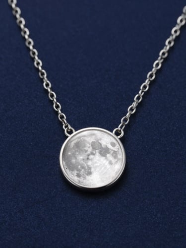 Macro product photography of a delicate sterling silver necklace catching sharp moonlight reflections, deep navy blue background, high-contrast studio lighting.