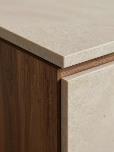 Extreme close-up of a high-end furniture join, rich walnut wood grain meeting smooth honed natural stone, diffused warm sidelight, focusing on the flawless architectural craftsmanship.