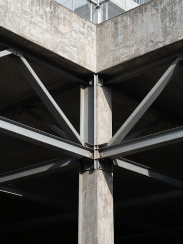 Symmetrical architectural details of a modern steel and concrete joint, high-contrast directional light, deep geometric shadows.