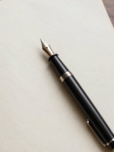 Close-up overhead study of a handwritten page on aged cream paper, a fountain pen resting diagonally across the sheet, soft diffused north-facing daylight, no text legible, surface texture of the paper prominent, quiet and archival
