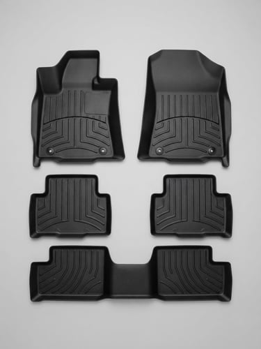 Overhead flat-lay of a custom-fit black polymer mat kit laid out symmetrically on a seamless light gray background, crisp studio lighting, sharp focus.