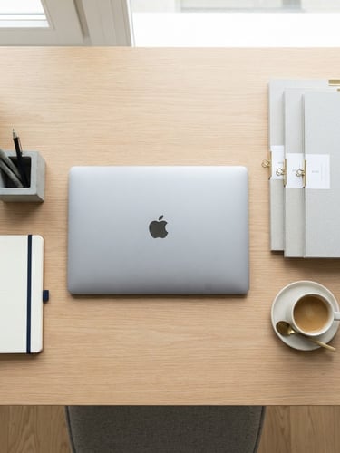 Overhead flat-lay of an impeccably organized modern desk with a laptop, neatly stacked labeled folders, and a ceramic mug in bright natural daylight, 35mm