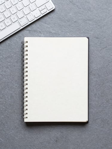 Overhead flat-lay of a clean, minimalist workspace, a single notebook, sleek keyboard, soft natural light, cool slate tones, 35mm