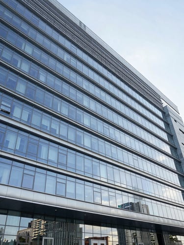 Wide architectural angle of a modern hospital facade in Baku, cool daylight, sharp metallic reflections, pristine glass windows.