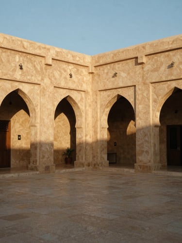Wide shot of a restored traditional Omani caravansary converted into a modern boutique hotel, courtyard with stone arches, dramatic golden-hour shadows, 35mm