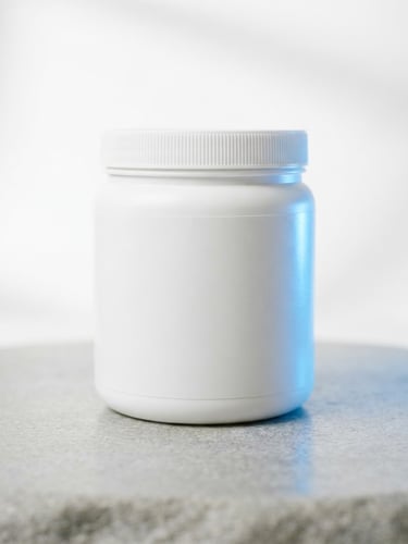 High-key studio shot of a clean white Creapure creatine jar on a smooth grey stone surface, glowing electric blue light accent from the right, minimalist composition, sharp focus, 35mm, bright natural daylight.