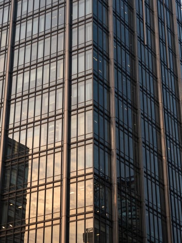 Architectural close-up of a modern glass skyscraper facade in Gurugram, high-contrast morning light reflecting off sharp steel structures.