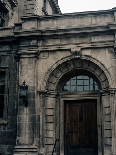 Close-up of a classic stone building facade with clean architectural lines under soft overcast daylight, elegant deep shadows, timeless editorial style