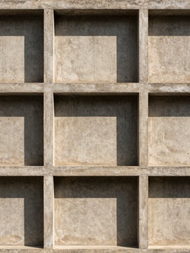 A straight-on architectural shot of a brutalist concrete facade with clean geometric lines and sharp shadows, neutral warm sand tones, 35mm