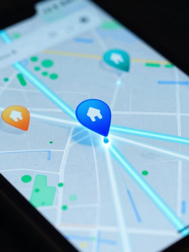 Macro close-up of a mobile screen displaying vibrant map pins and glowing data streams, cool cyan ambient lighting, high contrast, sharp focus, 35mm