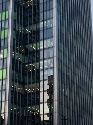 Sharp architectural crop of London financial district skyscraper reflecting cool morning light, deep slate shadows, 35mm lens