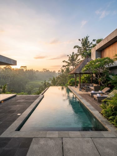 Architectural wide shot of a luxury Bali villa pool deck at sunrise, clean concrete lines, warm morning light, negative space on the left