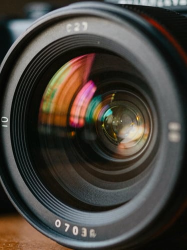 Extreme close-up of a high-end camera lens reflecting vibrant neon studio lights, cinematic film photography, 35mm grain, high contrast