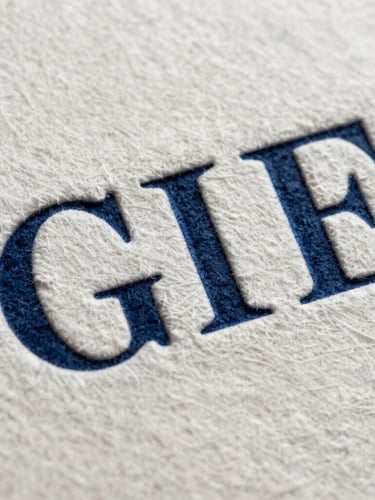 Extreme close-up of heavy-weight cotton paper debossed with clean serif typography, deep indigo ink visible in the grooves.