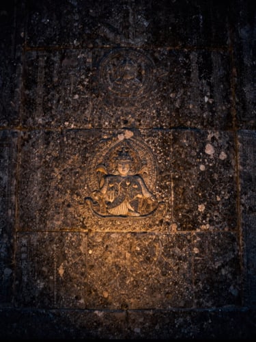 Extreme close-up of ancient weathered stone masonry with a subtle warm gold light reflecting off the texture, cinematic twilight, 35mm photography