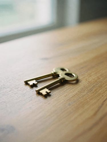 Close-up of physical assets, heavy brass keys resting on a solid oak table, soft natural daylight, shallow depth of field, medium format film