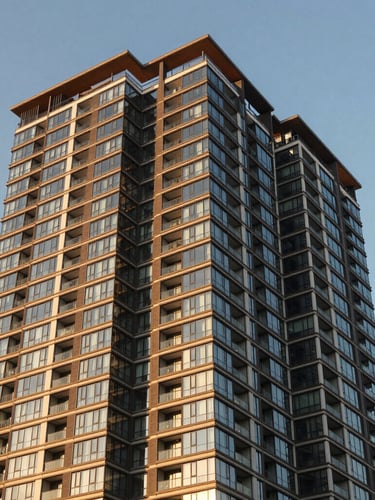 Warm editorial architectural photography of a modern high-rise condominium in Cebu, bright golden-hour sunlight reflecting off glass panels, clean vertical lines, 35mm.