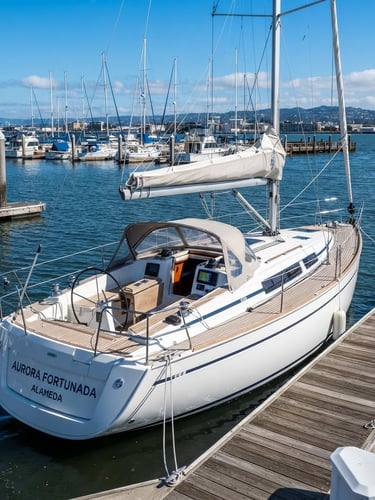 A crisp maritime photograph of the 2024 Bavaria 34 sailboat Aurora Fortunada docked at Fortman Marina in Alameda. Bright afternoon sun, deep blue water, high-contrast clean whites of the hull, wide-angle lens showing the modern rigging and teak deck.