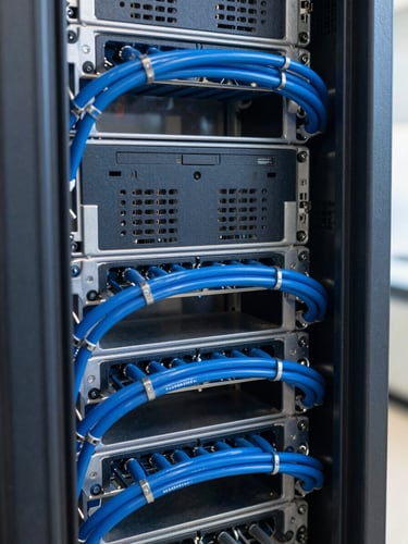 Close-up of structured server rack with clean blue cable management, natural industrial lighting, sharp focus