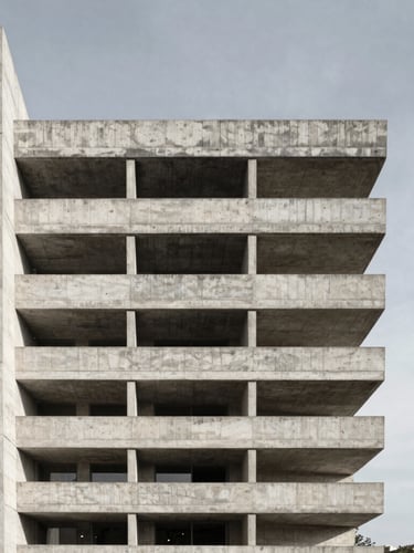 Symmetrical straight-on wide-angle shot of a completed brutalist concrete and exposed steel residence, harsh natural sunlight, sharp focus, 24mm lens, negative space on the right.