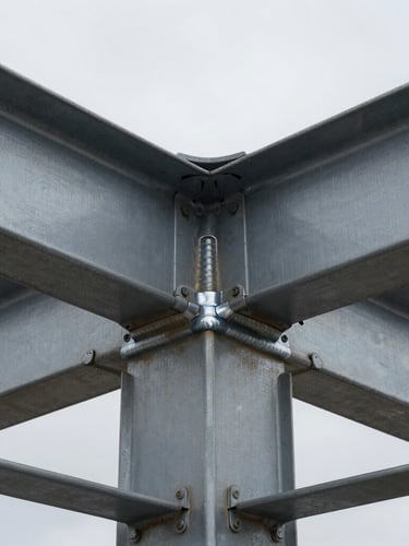 Extreme close-up of a structural steel joint, welded with millimeter precision, harsh overcast daylight highlighting the raw metallic texture, desaturated industrial tones.