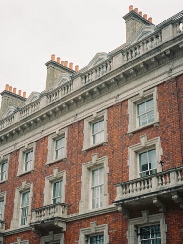 Architectural crop of Georgian brickwork and stone cornices in Hanover Square, desaturated cool tones, soft overcast London daylight, 35mm film.