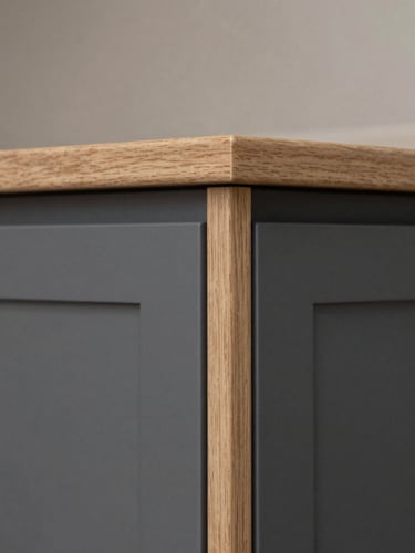 Architectural close-up of a custom kitchen cabinet corner, perfect flush joints, graphite panel meeting light oak wood, soft side-light, 35mm lens
