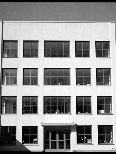 Stark architectural photography of a high-tech cleanroom laboratory, high-contrast monochrome, sharp focus, direct hard sunlight, 35mm
