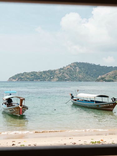 Bright daylight view of Chalong bay with quiet boats moored, soft tropical hills in the background, realistic framing, 35mm lens