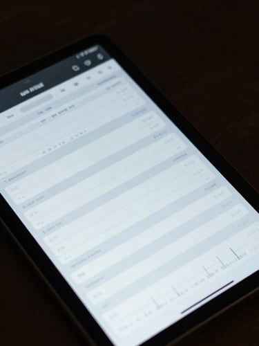 Macro detailed shot of a high-resolution dark mode dashboard interface on a tablet, displaying structured schedules and clean data graphs under soft cool light