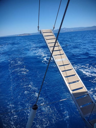 Swimming ladder over the crystal-clear Aegean Sea during a private sailing cruise in Halkidiki