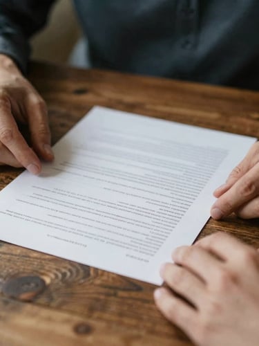 A close-up of hands reviewing clear financial documents on a rustic wooden table, soft natural daylight, rich muted tones, shallow depth of field, 35mm